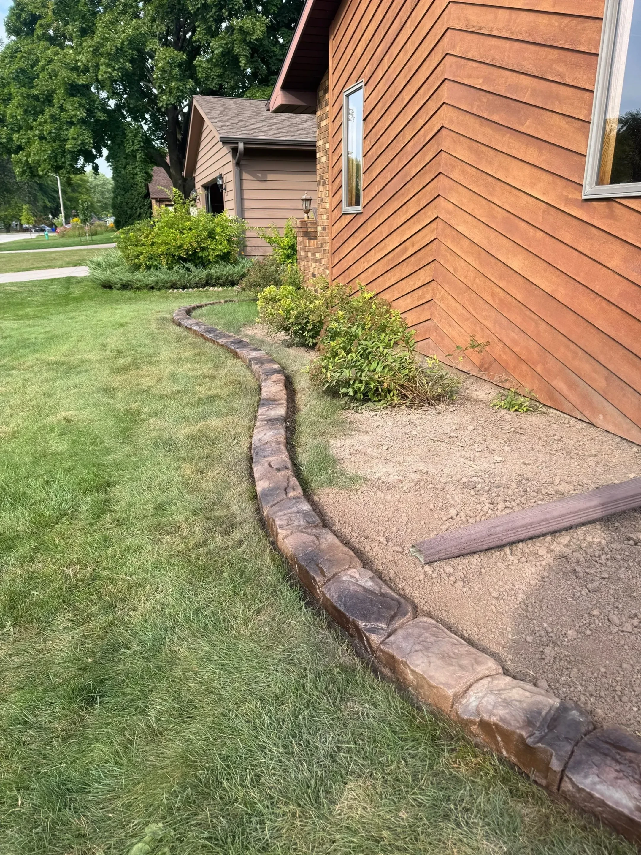 Curved mower curbing along backyard garden bed
